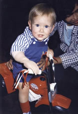 Toddler on trike wearing prosthetic hand